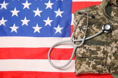 Photo of Stethoscope and military uniform on USA flag, top view