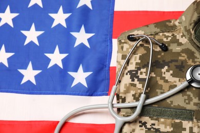 Photo of Stethoscope and military uniform on USA flag, top view