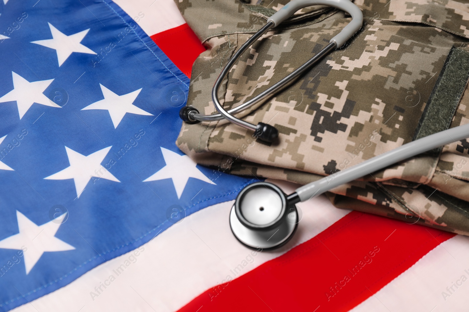 Photo of Stethoscope and military uniform on USA flag, closeup