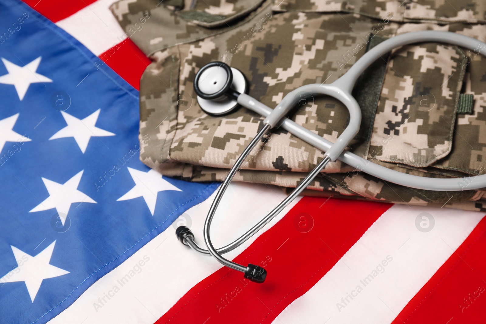 Photo of Stethoscope and military uniform on USA flag, closeup