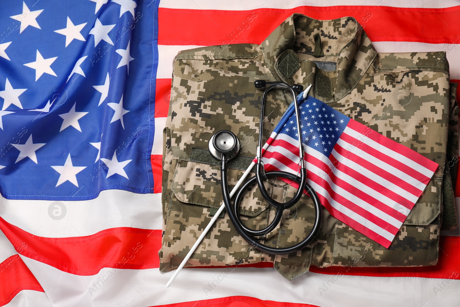 Photo of Stethoscope and military uniform on USA flag, top view