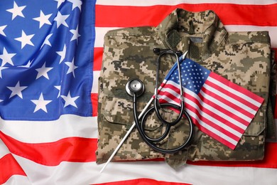 Stethoscope and military uniform on USA flag, top view