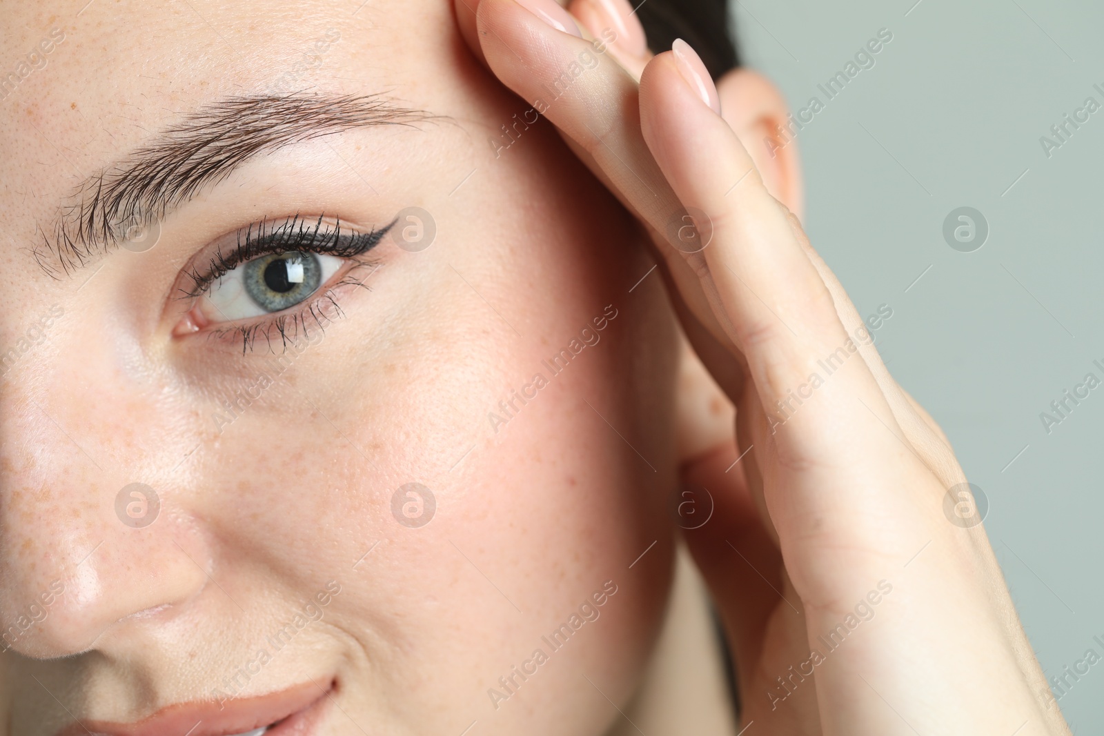 Photo of Young woman with beautiful eyebrow on light background, closeup