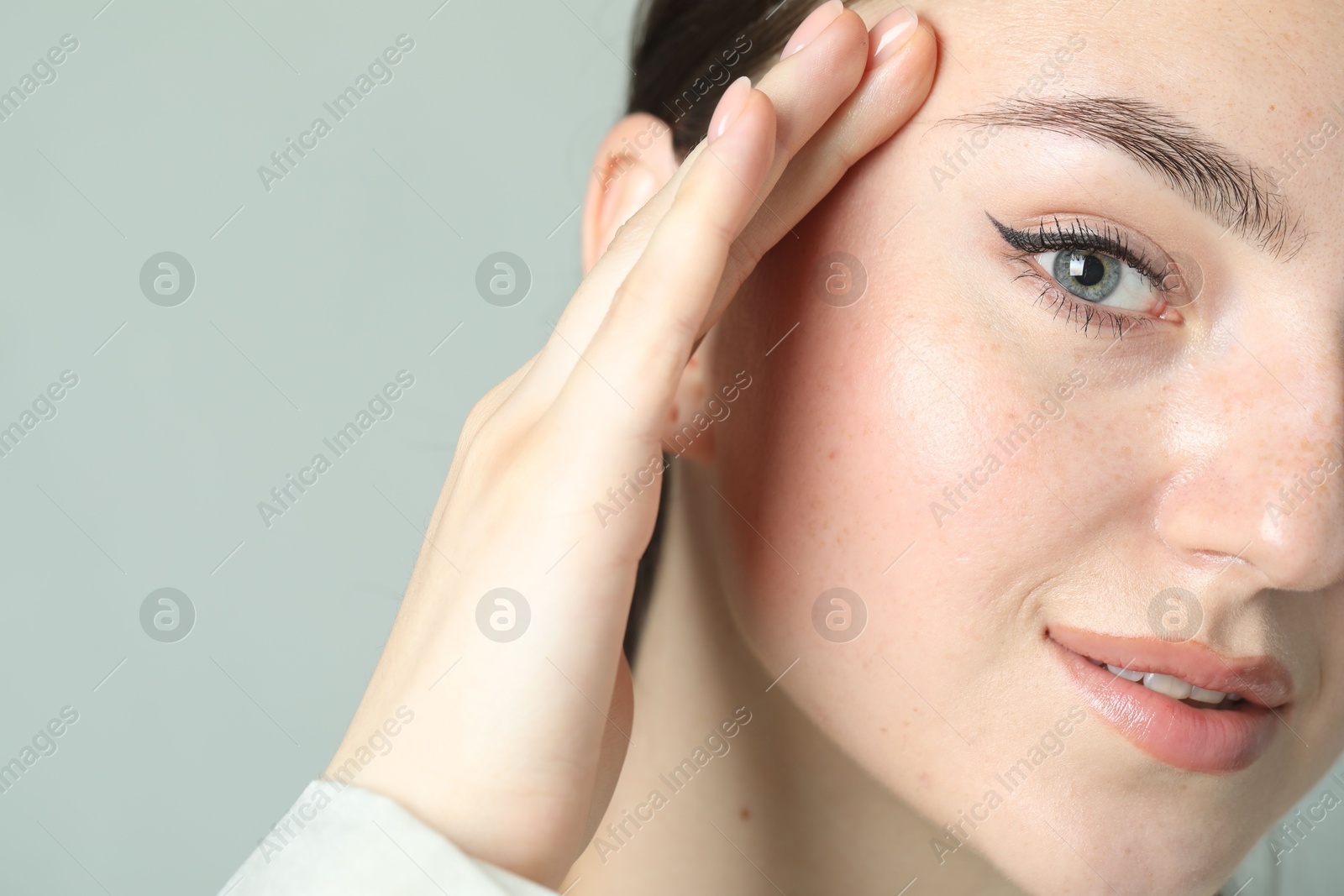 Photo of Young woman with beautiful eyebrow on light background, closeup and space for text