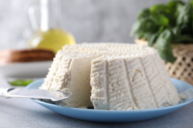 Tasty ricotta (cream cheese) and knife on grey table, closeup