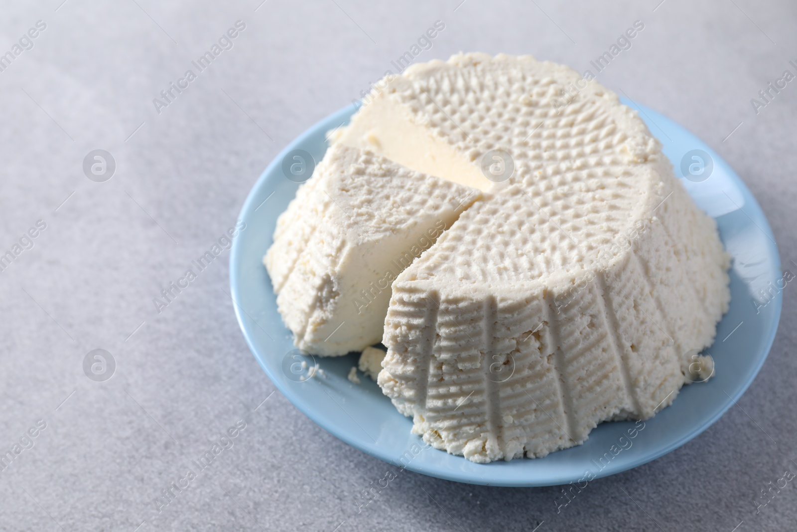 Photo of Tasty ricotta (cream cheese) on grey table, space for text