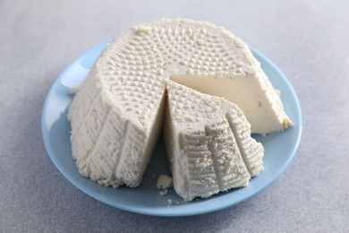 Tasty ricotta (cream cheese) on grey table