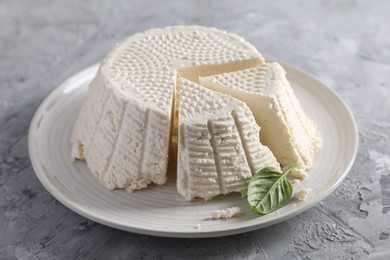 Photo of Tasty ricotta (cream cheese) on grey textured table