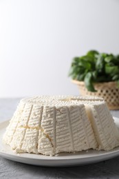 Tasty ricotta (cream cheese) on grey textured table, closeup