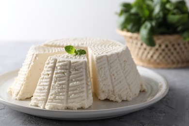 Photo of Tasty ricotta (cream cheese) on grey textured table, closeup