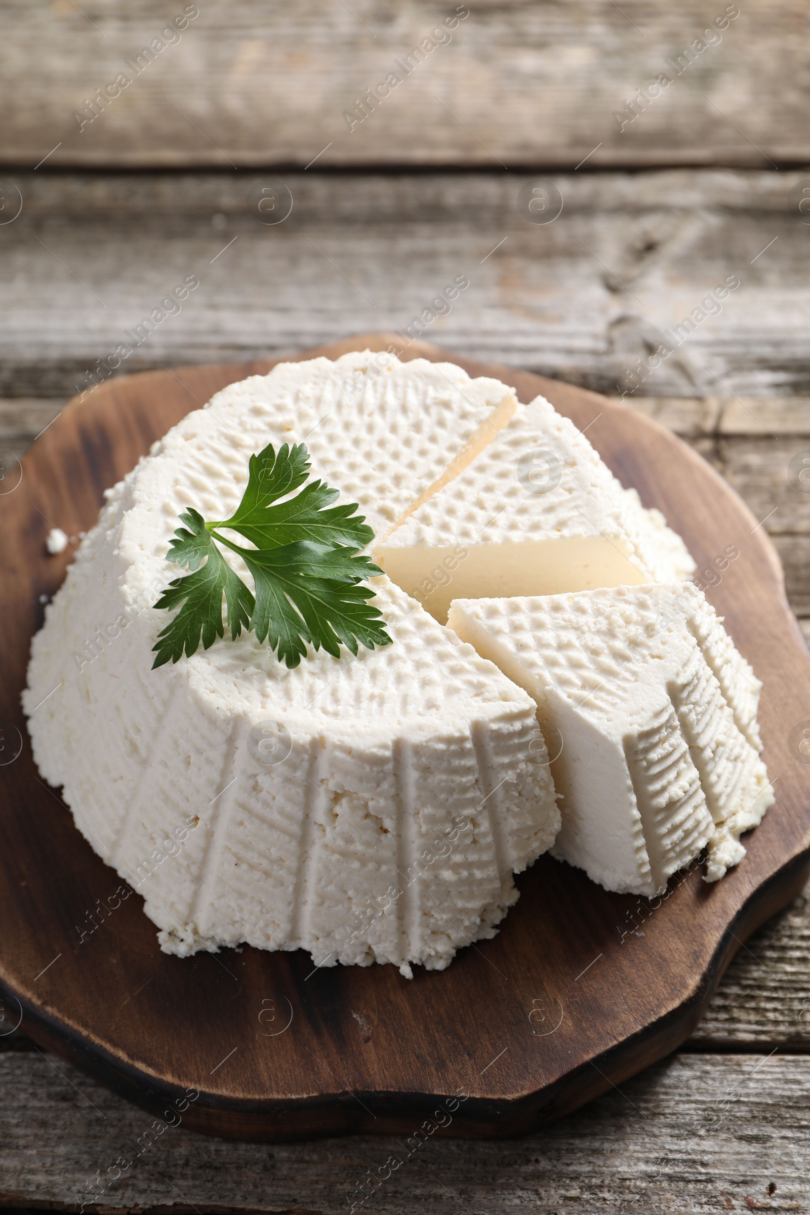 Photo of Tasty ricotta (cream cheese) on wooden table, closeup