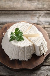 Tasty ricotta (cream cheese) on wooden table, closeup