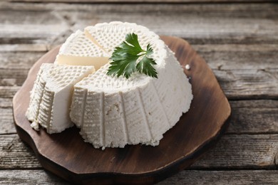 Photo of Tasty ricotta (cream cheese) on wooden table, closeup