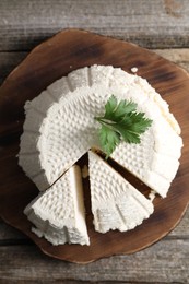 Tasty ricotta (cream cheese) on wooden table, top view