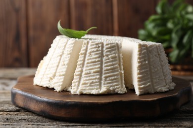 Tasty ricotta (cream cheese) on wooden table, closeup