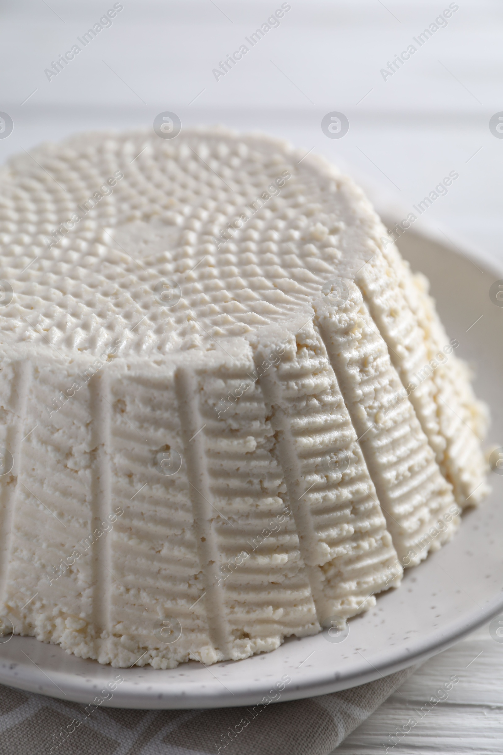 Photo of Tasty ricotta (cream cheese) on white wooden table, closeup