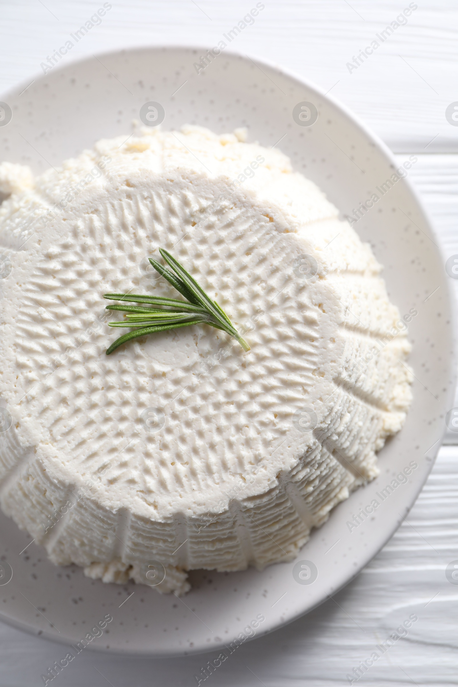 Photo of Tasty ricotta (cream cheese) on white wooden table, top view