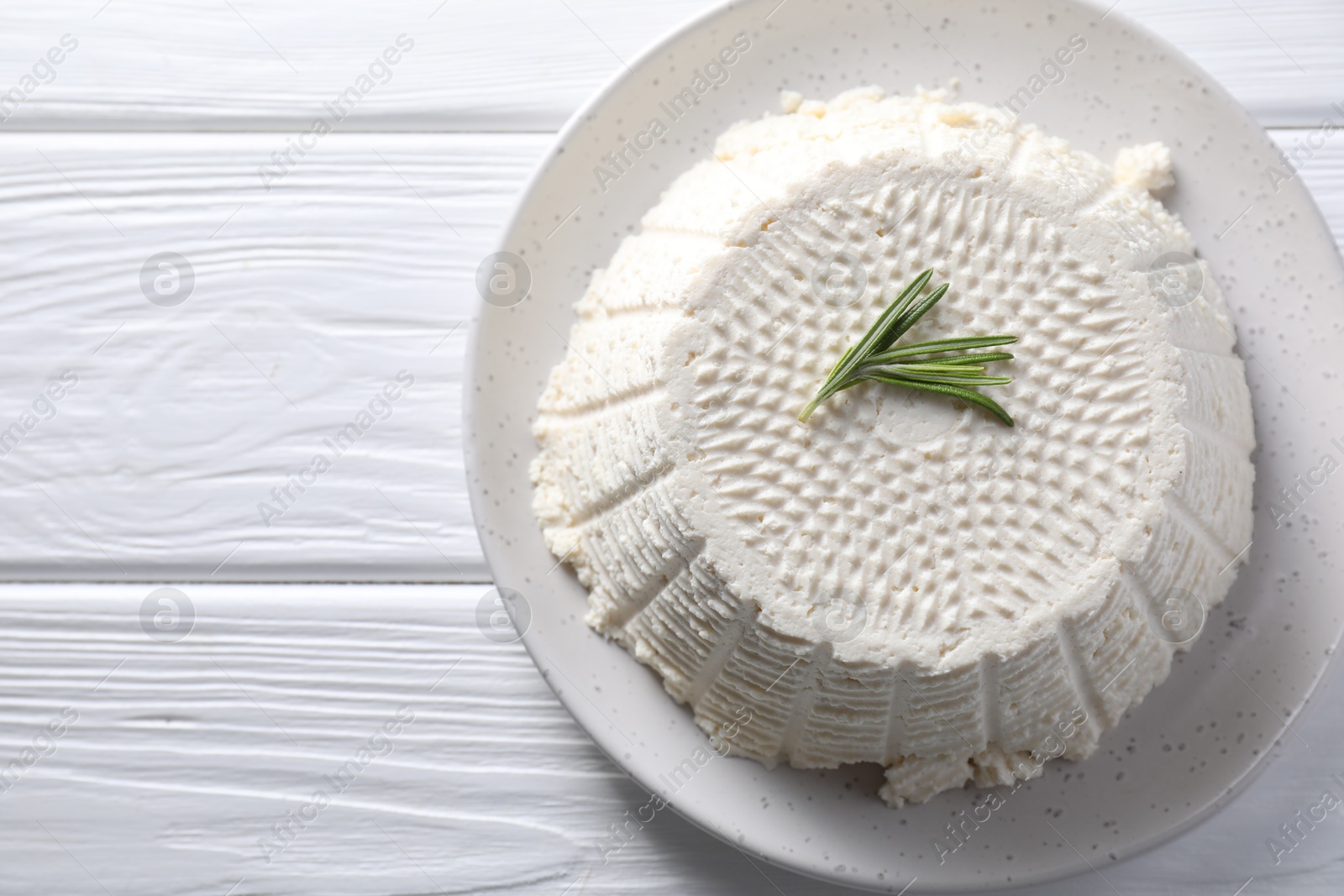 Photo of Tasty ricotta (cream cheese) on white wooden table, top view. Space for text