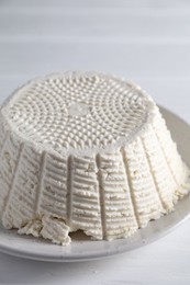 Photo of Tasty ricotta (cream cheese) on white wooden table, closeup