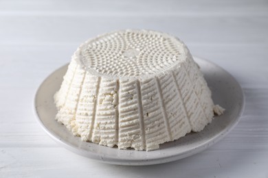 Tasty ricotta (cream cheese) on white wooden table