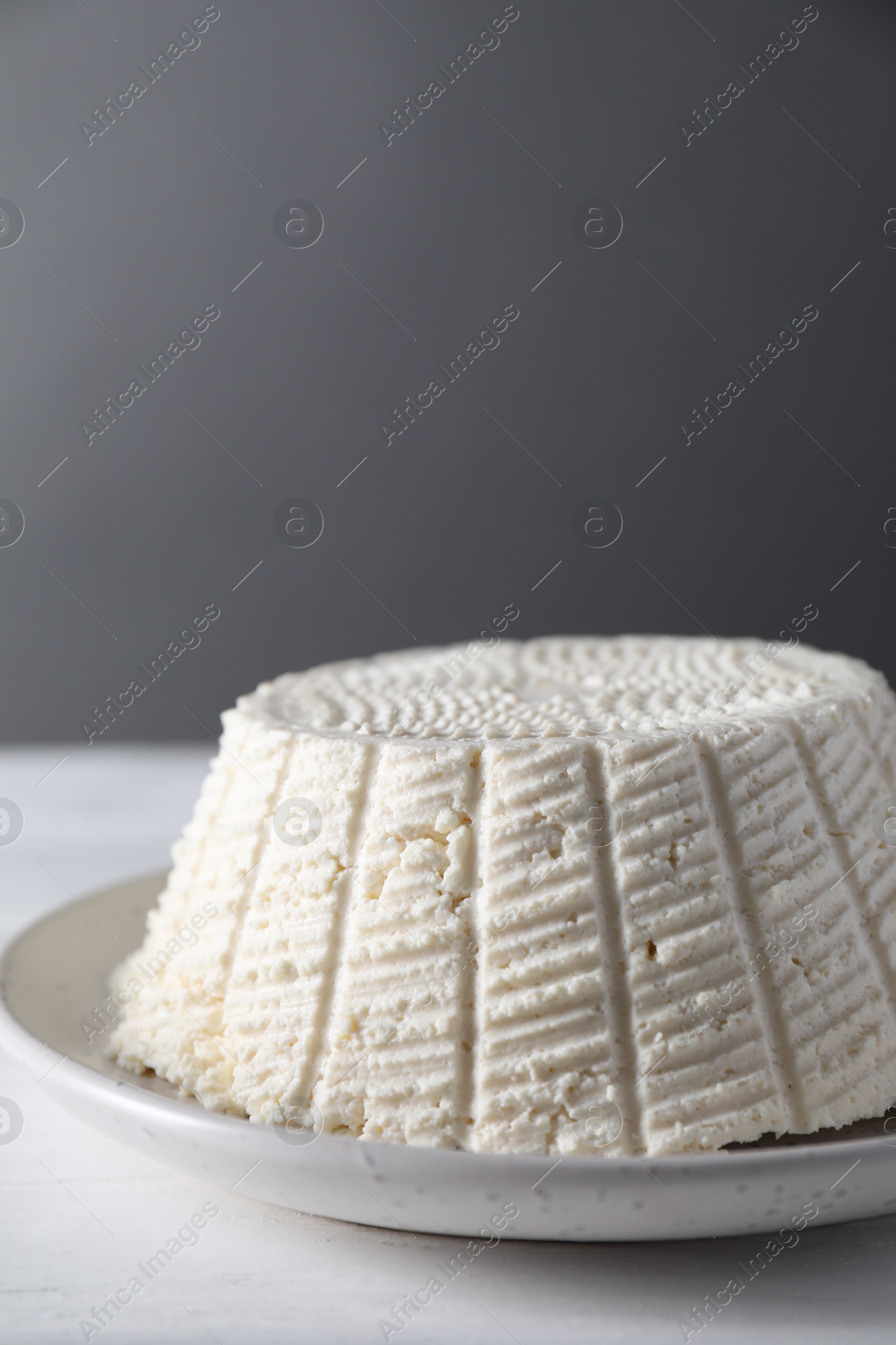 Photo of Tasty ricotta (cream cheese) on white wooden table, closeup