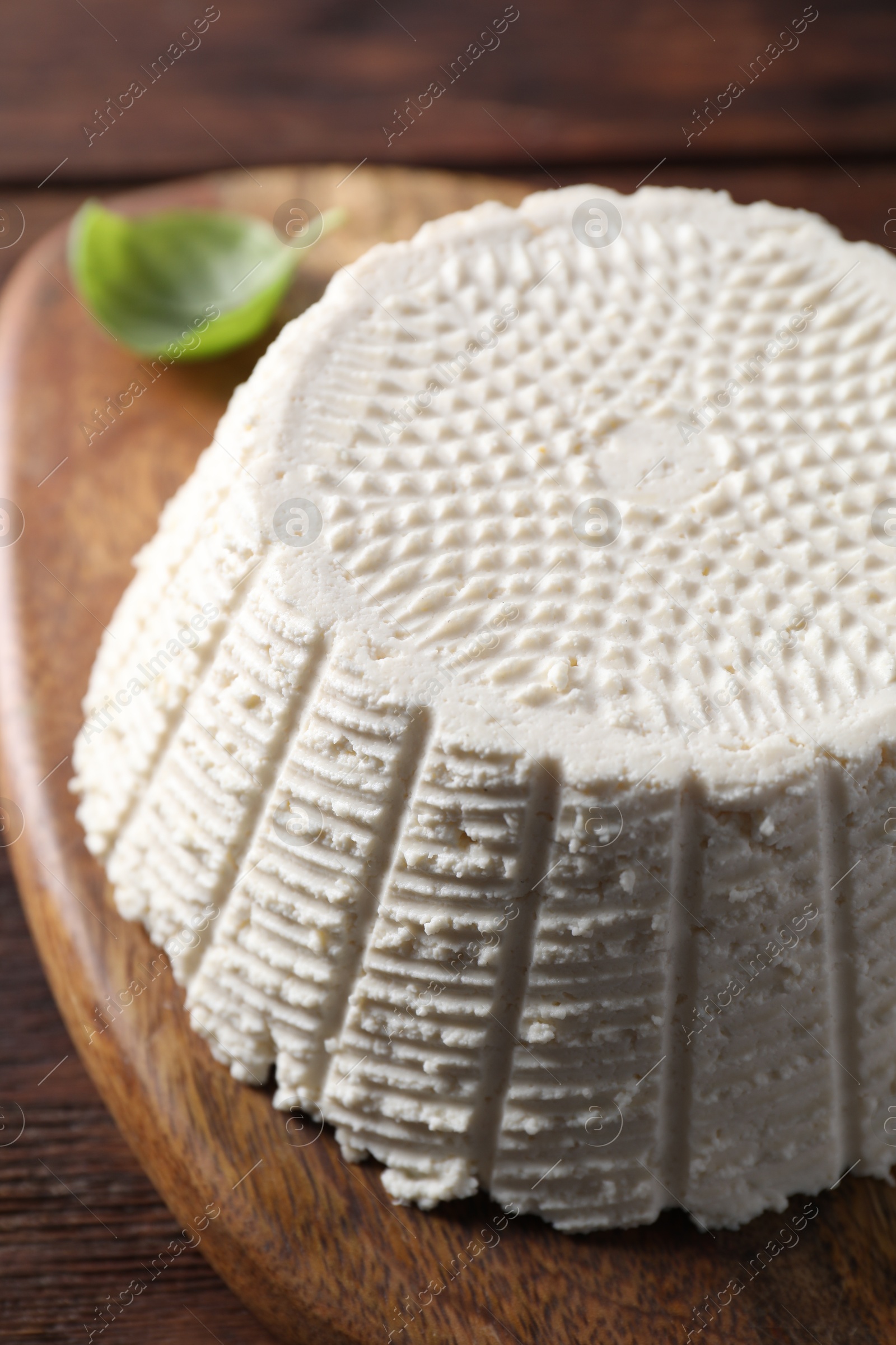 Photo of Tasty ricotta (cream cheese) on wooden table, closeup