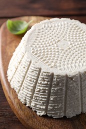 Tasty ricotta (cream cheese) on wooden table, closeup