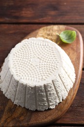 Photo of Tasty ricotta (cream cheese) on wooden table