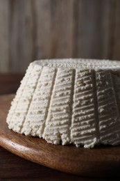 Tasty ricotta (cream cheese) on wooden table, closeup