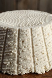 Photo of Tasty ricotta (cream cheese) on wooden table, closeup