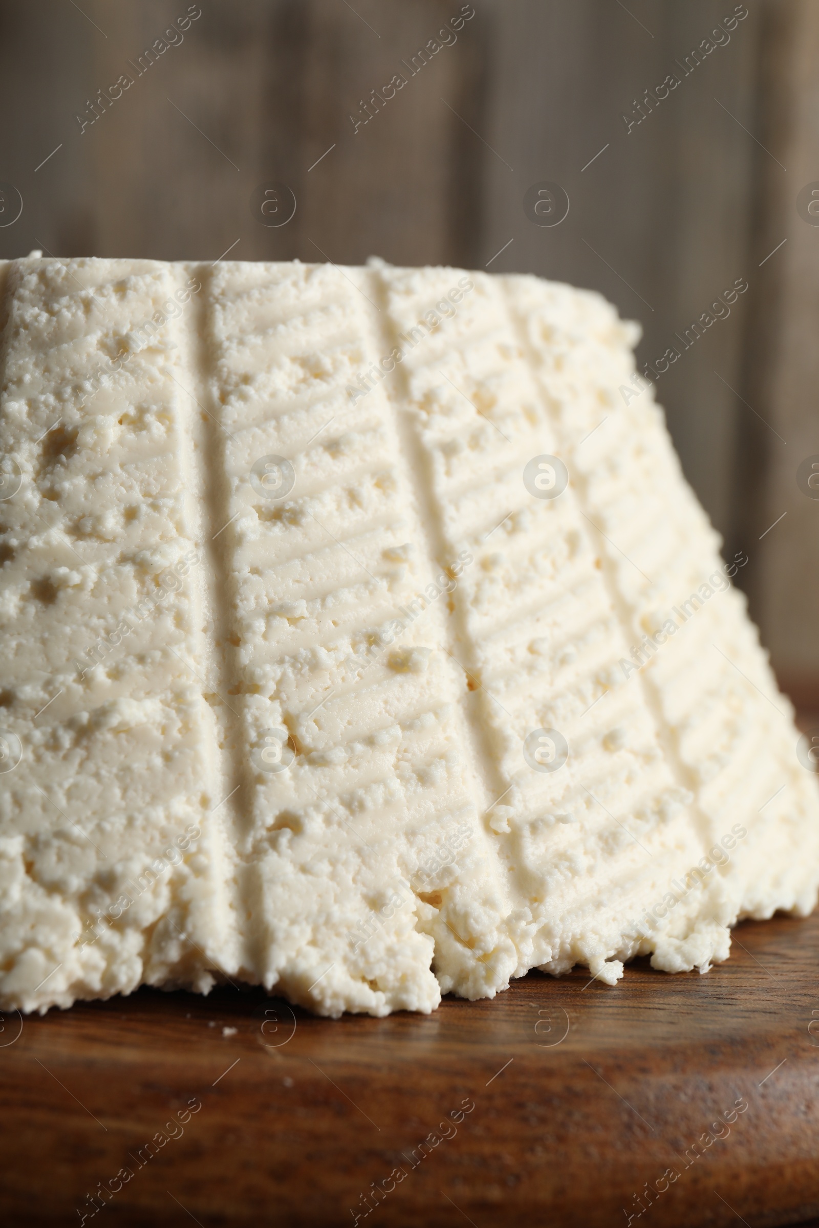 Photo of Tasty ricotta (cream cheese) on wooden table, closeup