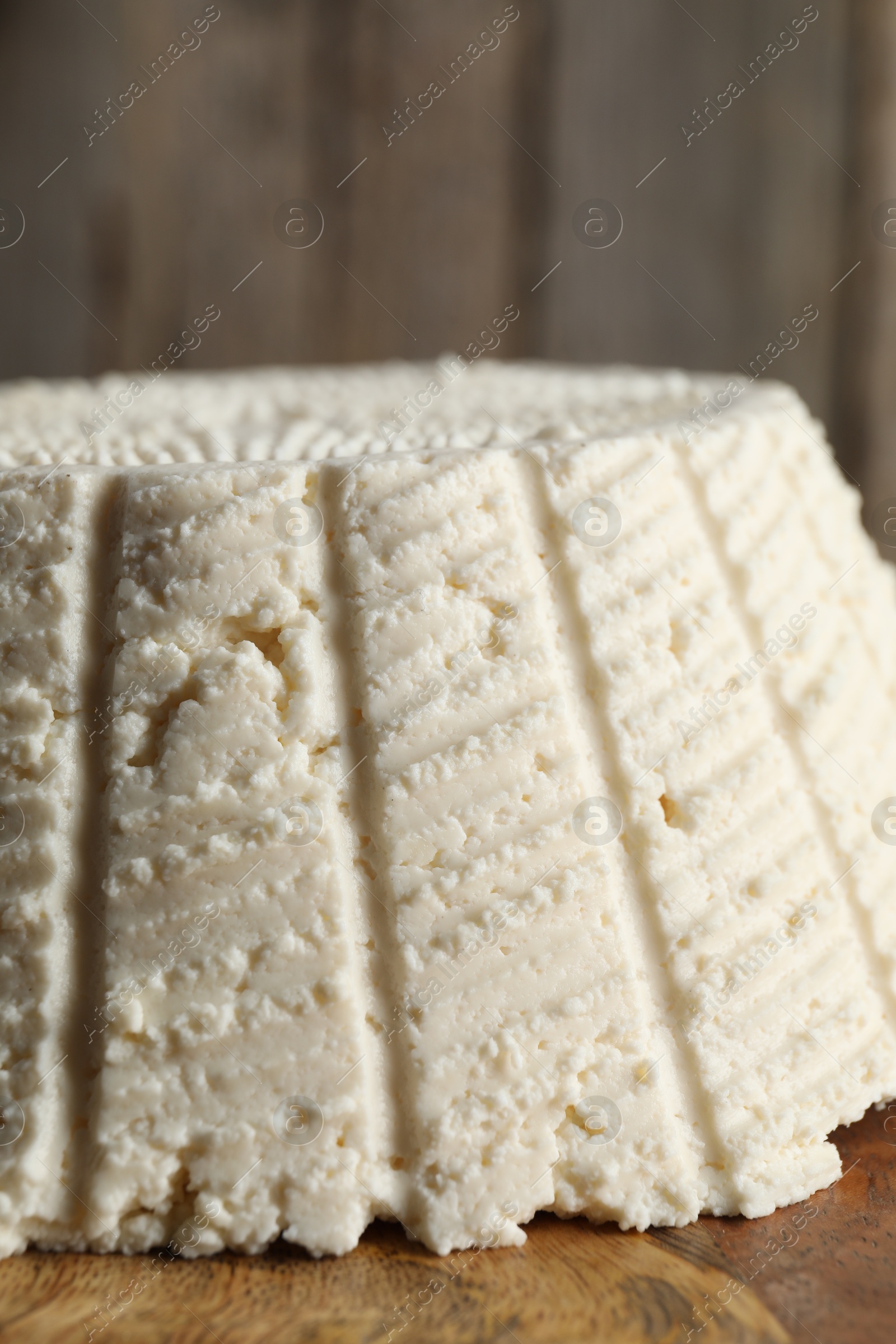 Photo of Tasty ricotta (cream cheese) on wooden table, closeup