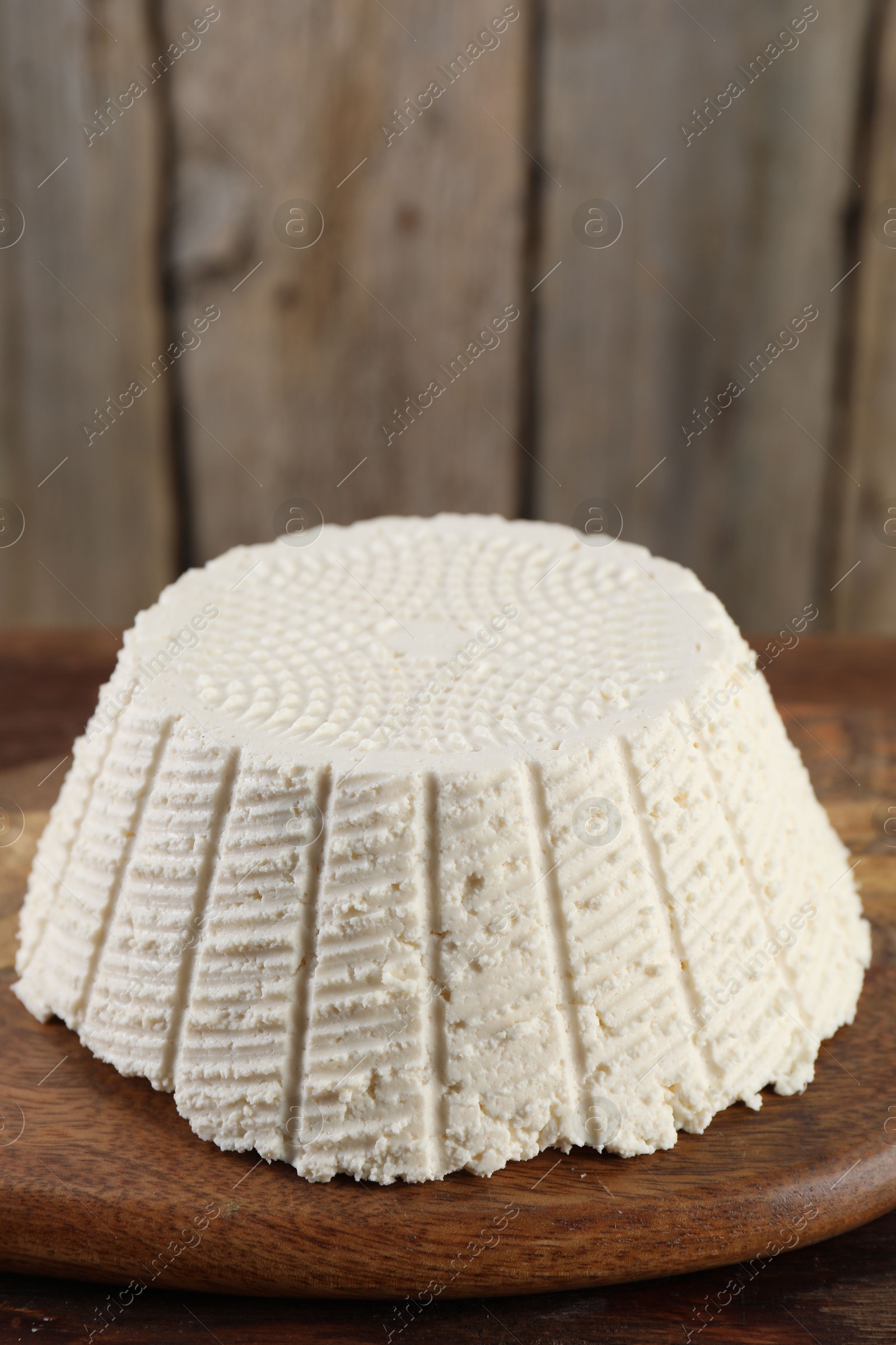 Photo of Tasty ricotta (cream cheese) on wooden table, closeup