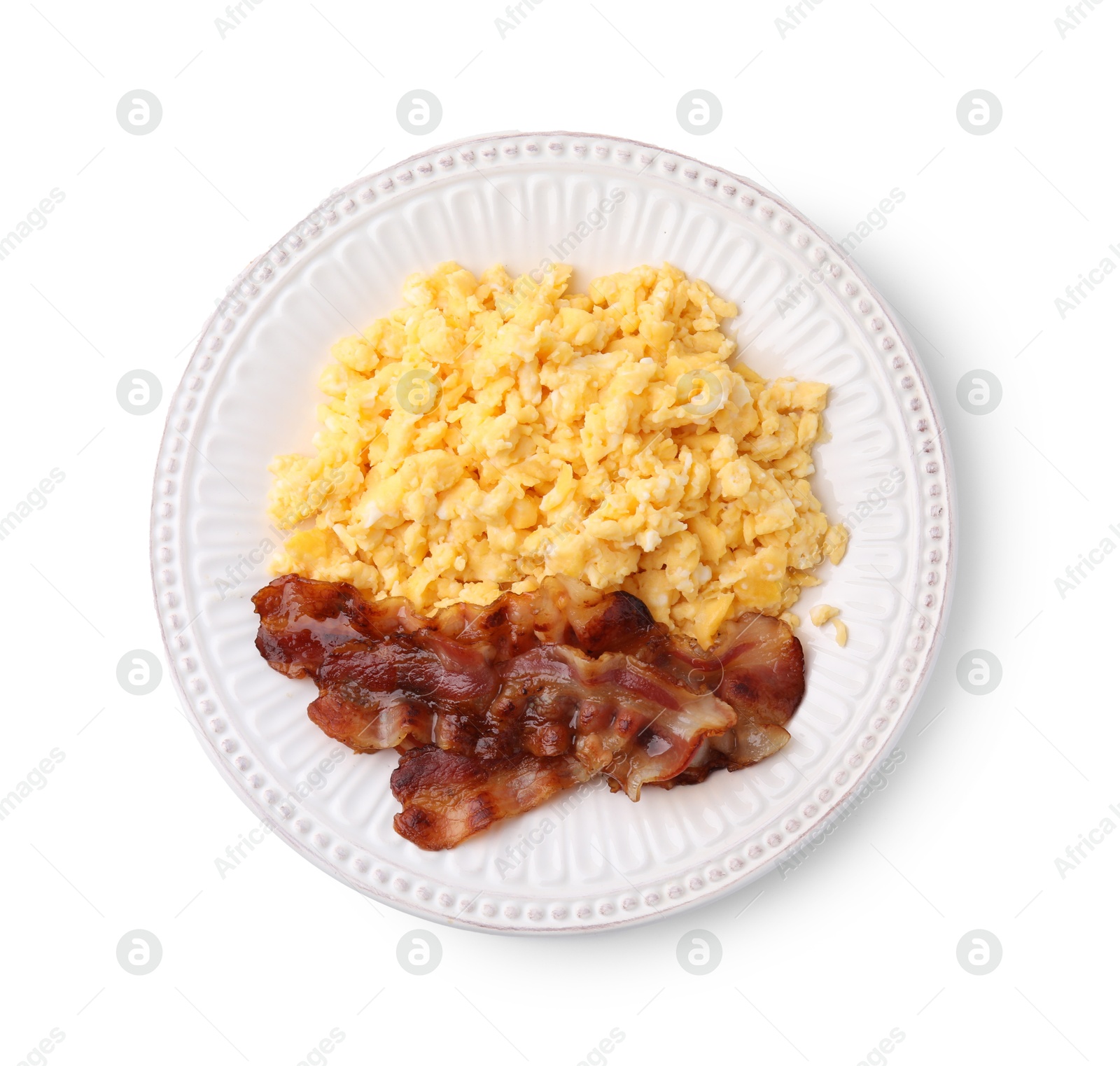 Photo of Delicious scrambled eggs with bacon on plate isolated on white, top view