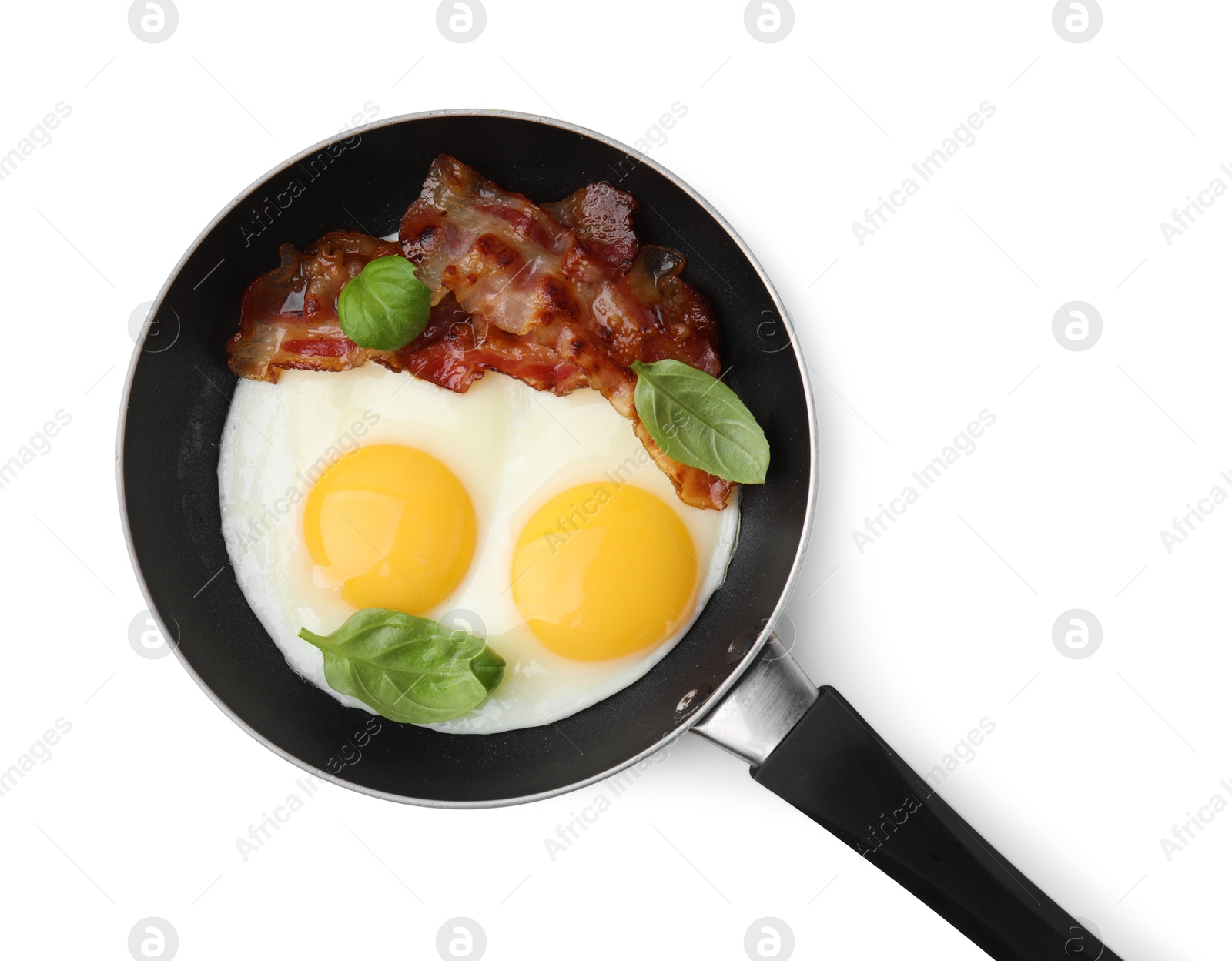 Photo of Fried eggs, bacon and basil in frying pan isolated on white, top view