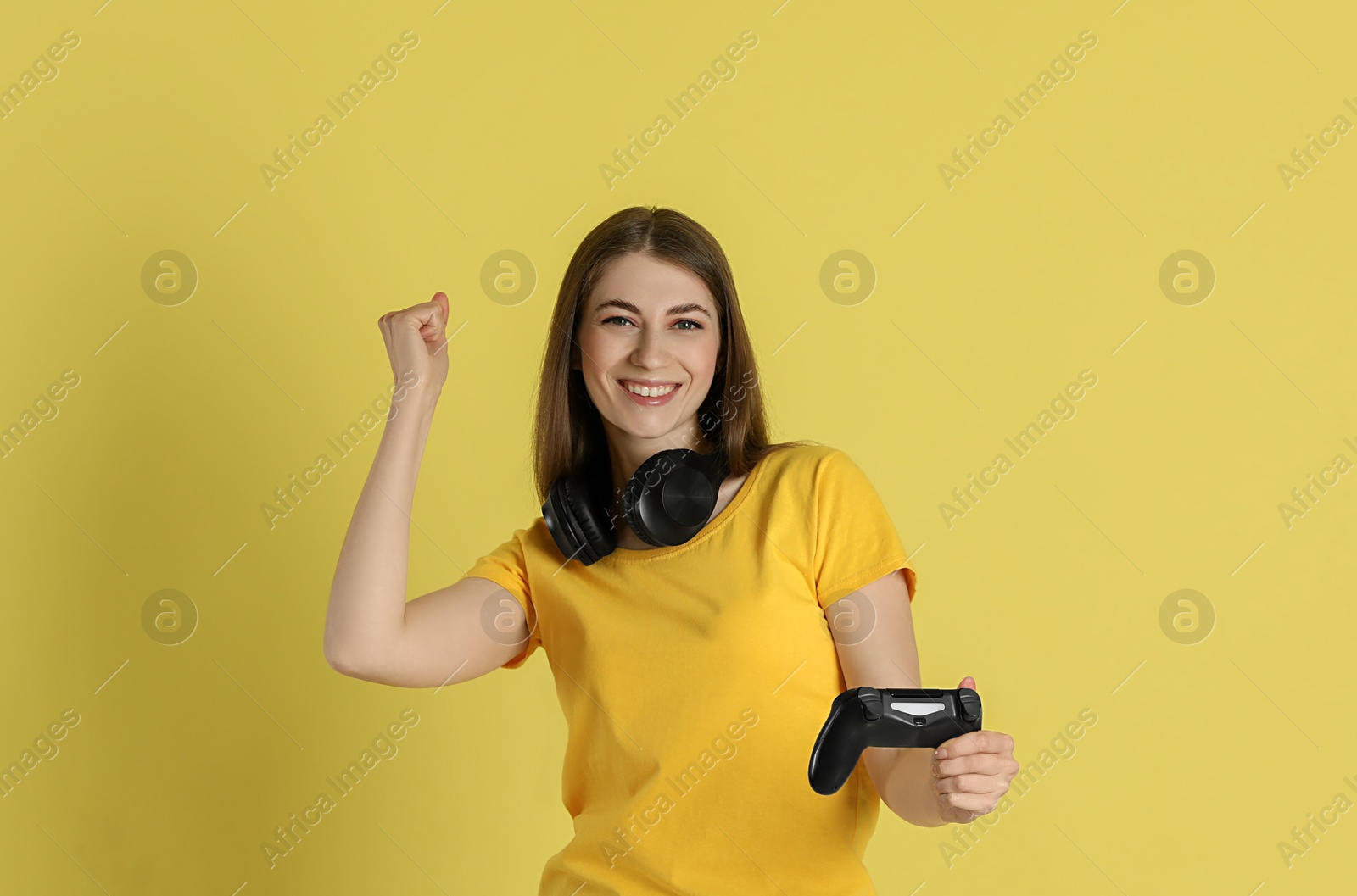 Photo of Happy woman with controller on yellow background