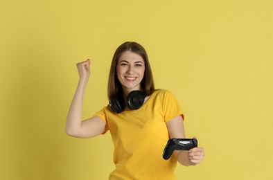 Photo of Happy woman with controller on yellow background