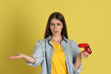 Photo of Unhappy woman with controller on yellow background