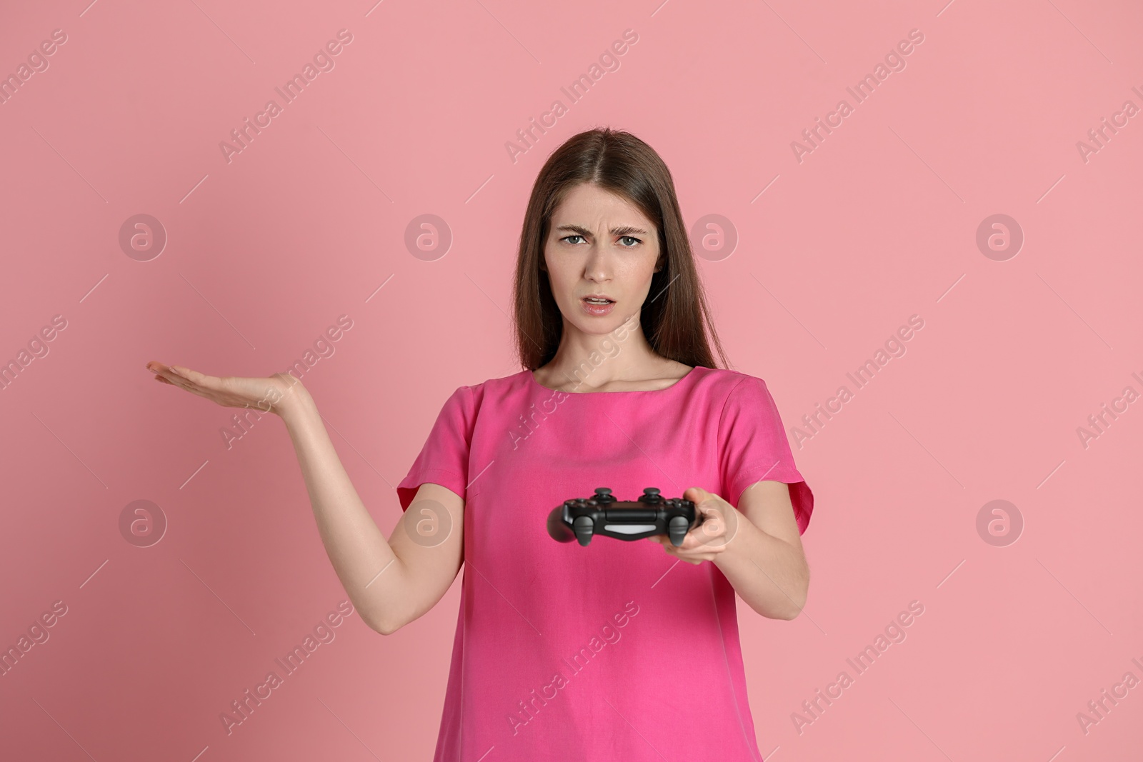 Photo of Woman playing video games with controller on pink background