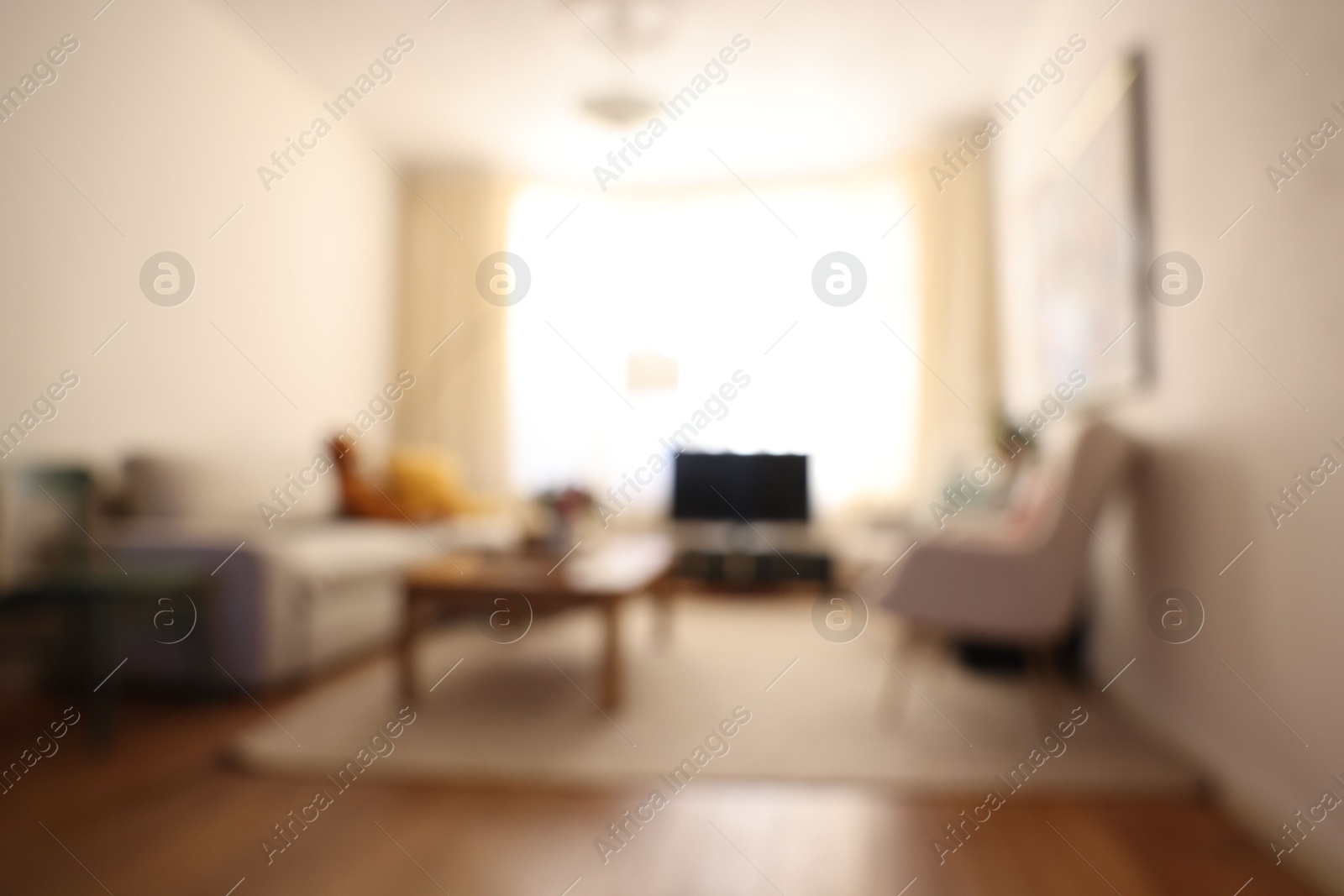 Photo of Blurred view of cozy living room with modern furniture and TV set. Interior design