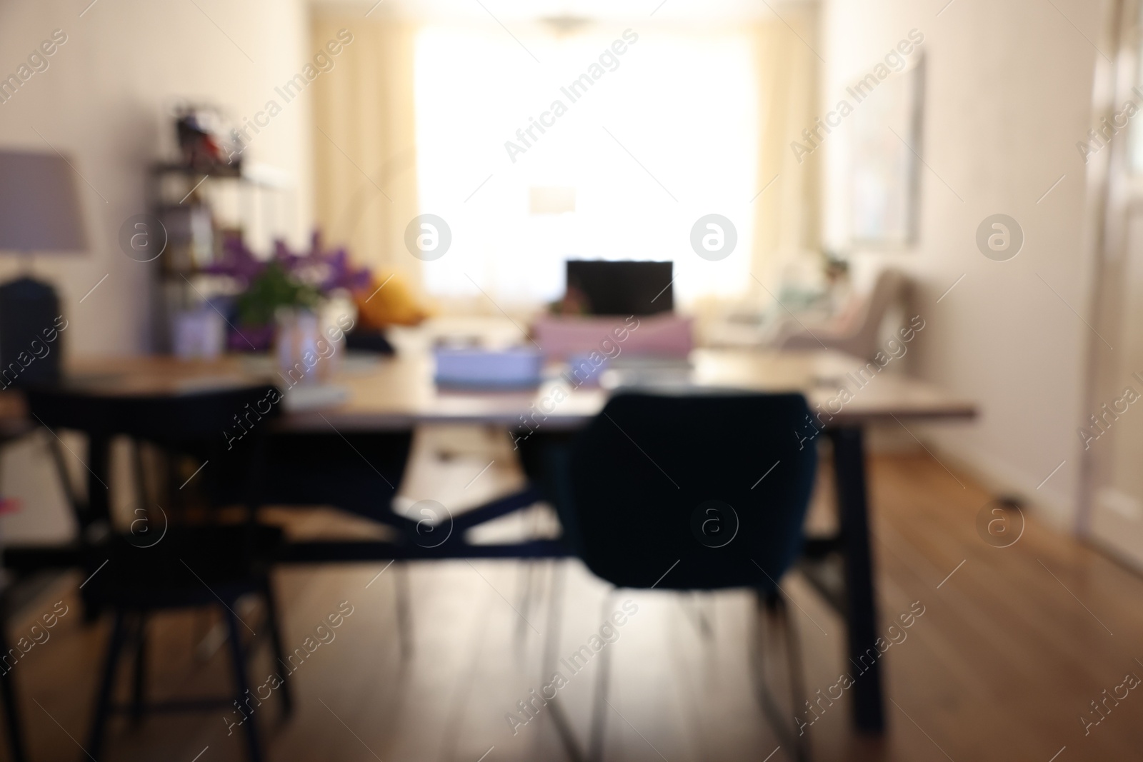 Photo of Stylish dining room interior with comfortable furniture and bouquet of flowers, blurred view