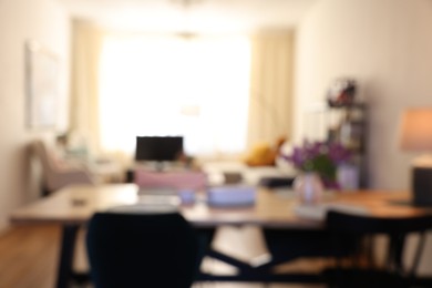 Photo of Stylish dining room interior with comfortable furniture and bouquet of flowers, blurred view