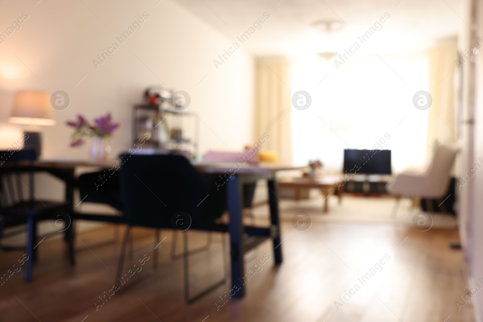 Photo of Stylish dining room interior with comfortable furniture and bouquet of flowers, blurred view