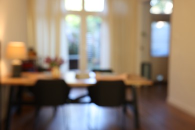 Photo of Stylish dining room interior with comfortable furniture and bouquet of flowers, blurred view