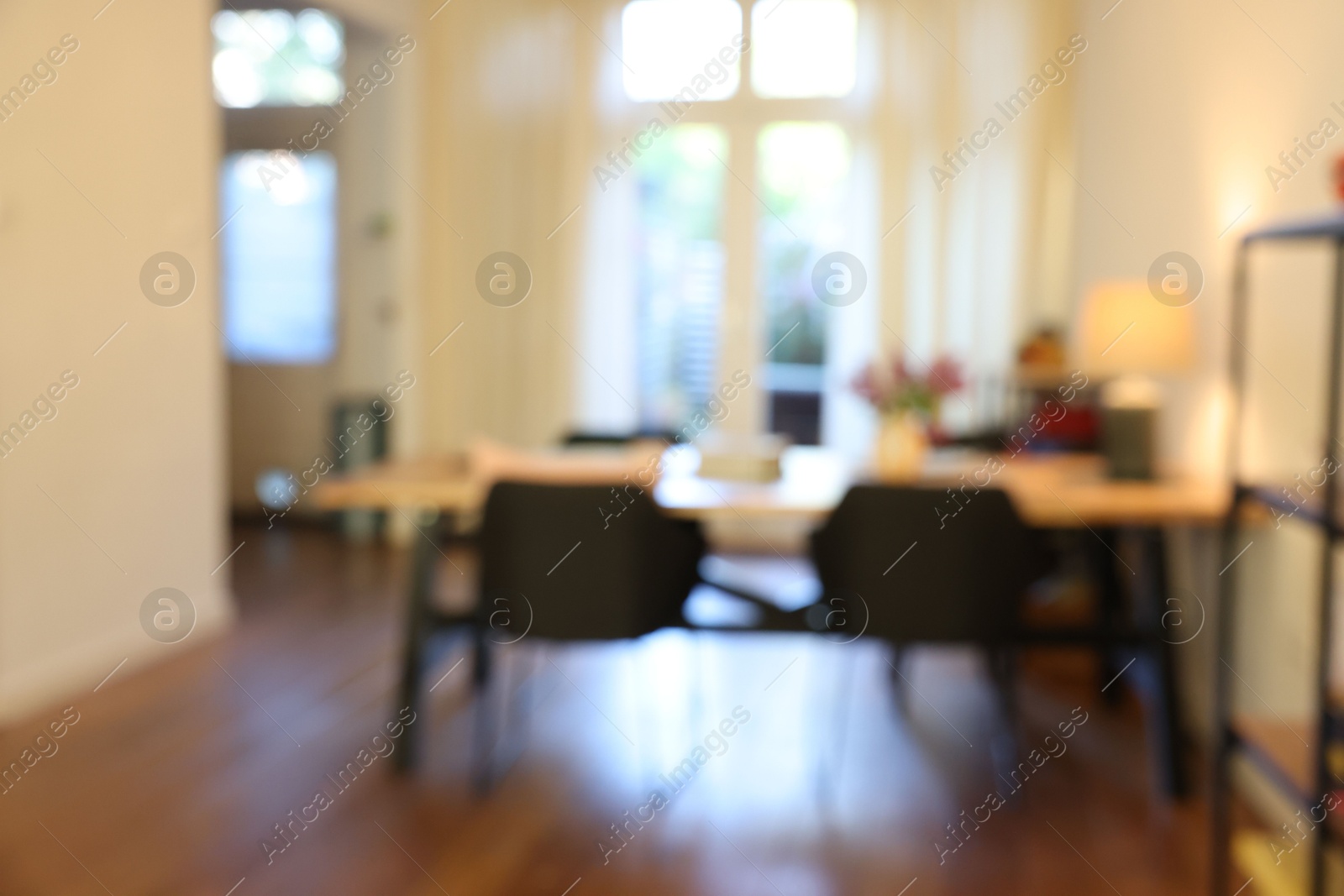 Photo of Stylish dining room interior with comfortable furniture and bouquet of flowers, blurred view