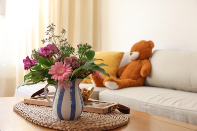 Bouquet of beautiful flowers in vase on wooden table at home. Space for text