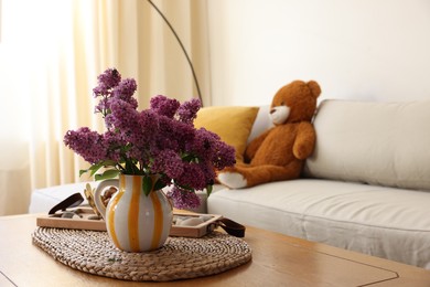 Photo of Beautiful fragrant lilac flowers in vase on table at home. Space for text