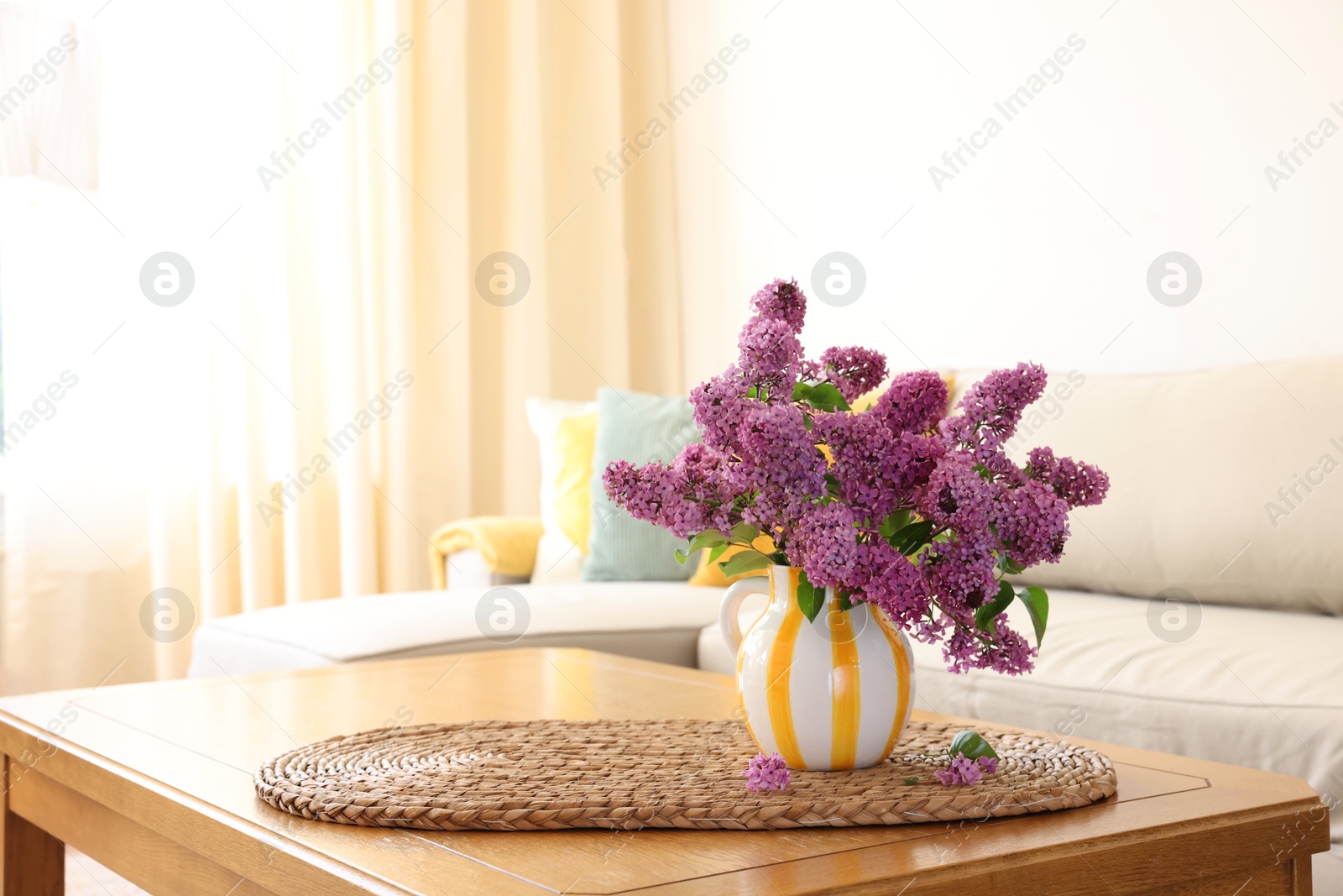 Photo of Beautiful fragrant lilac flowers in vase on table at home. Space for text