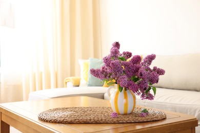 Photo of Beautiful fragrant lilac flowers in vase on table at home. Space for text