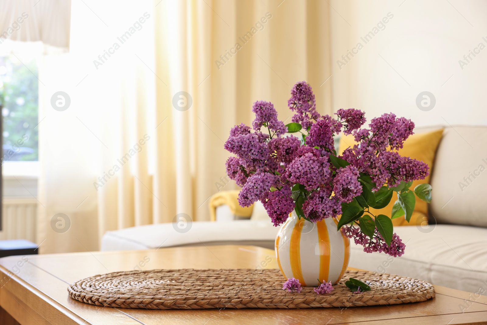 Photo of Beautiful fragrant lilac flowers in vase on table at home. Space for text